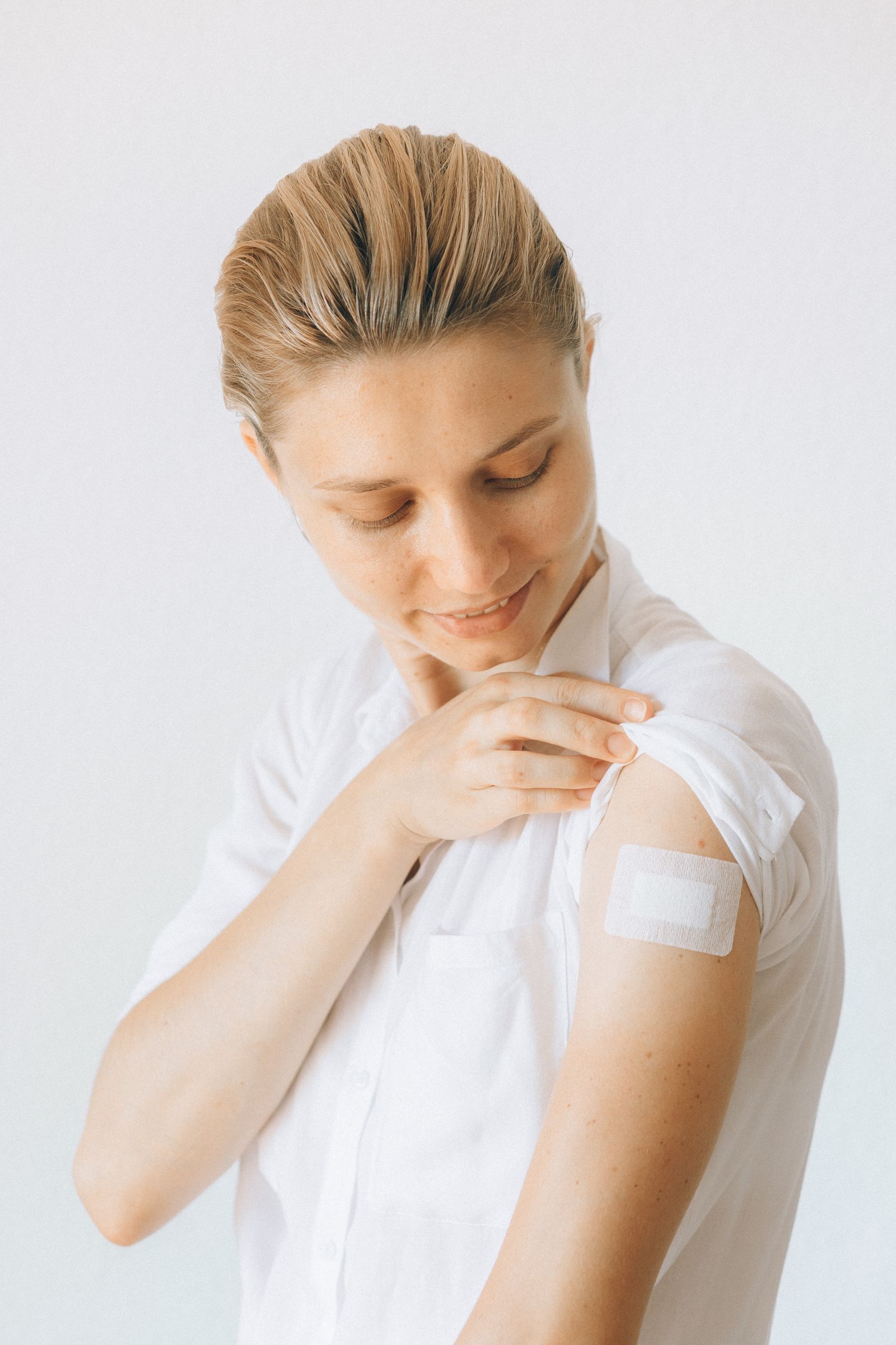 Smiling woman with a small bandage on her upper arm