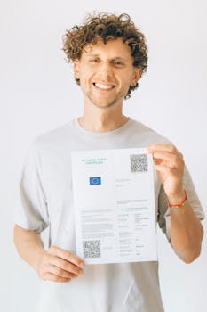 A cheerful man displays his EU Digital COVID Certificate proudly indoor.
