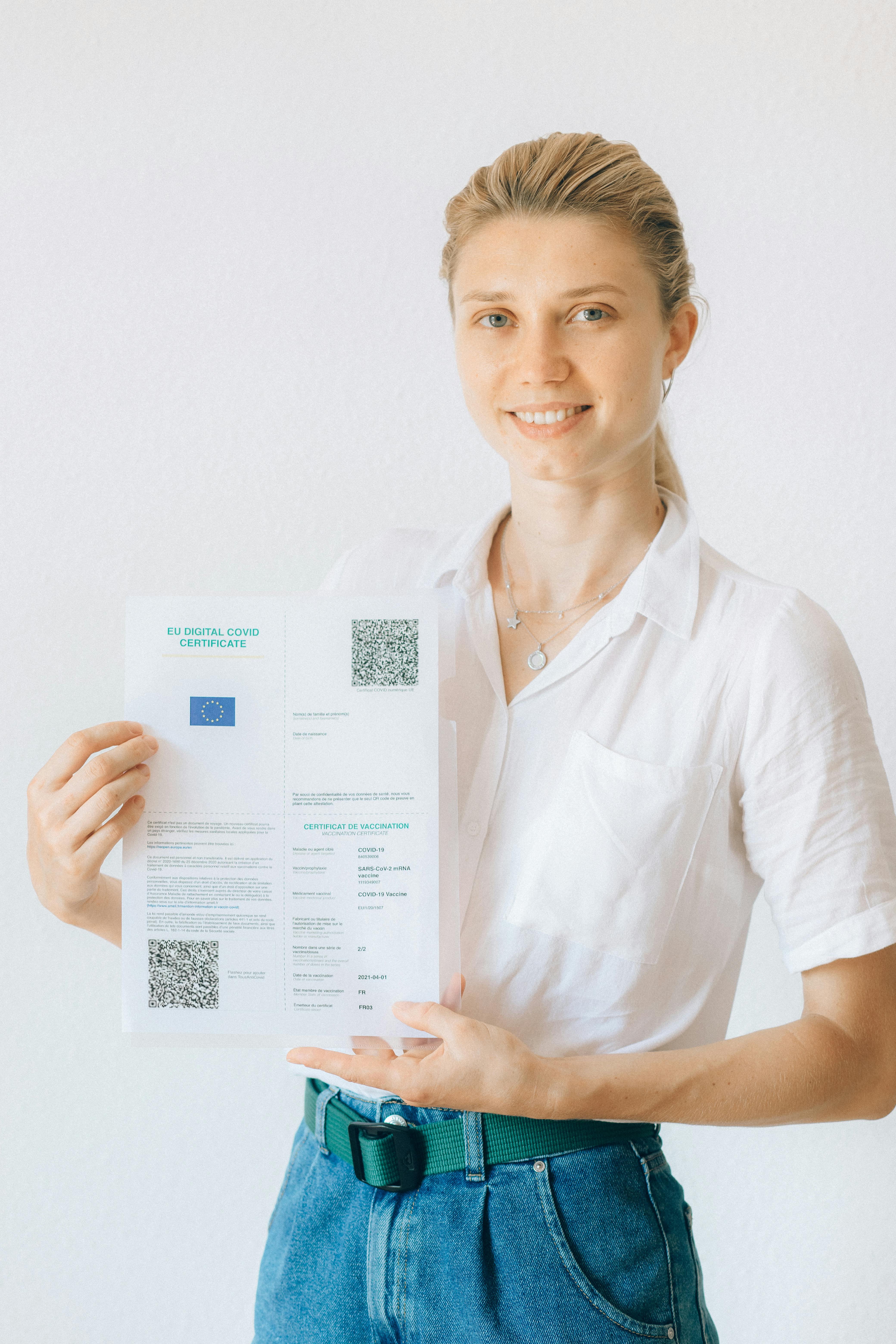 woman in white button up shirt holding white printer paper