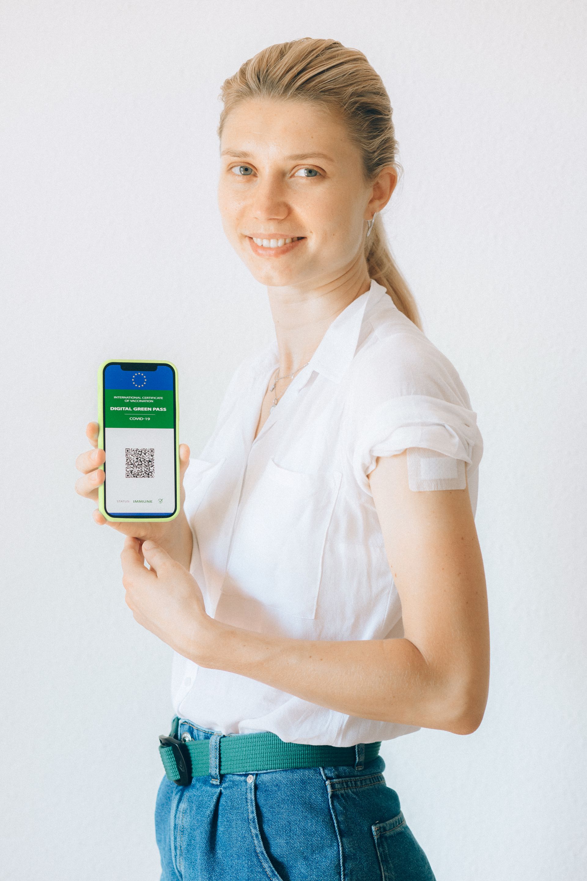 Person holding smartphone displaying a QR code for digital verification at point of service