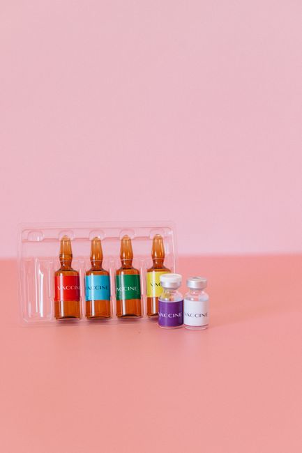 Vibrant vaccine ampoules and vials on a pink surface, representing healthcare and protection. Vibrant vaccine ampoules and vials on a pink surface, representing healthcare and protection.