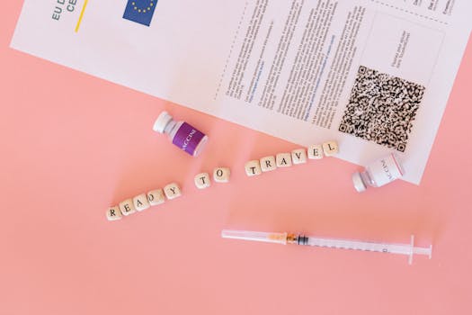 COVID-19 vaccine certificate with vials and syringe on pink background, ready to travel concept.