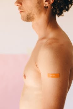 Close-up of man's bare arm with a vaccination bandage, symbolizing health and protection.