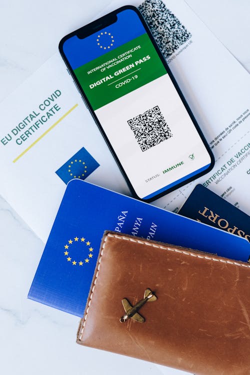 Free Passport Holder Beside a Cellphone on Top of a Certificate Stock Photo