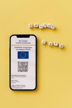 Smartphone showing EU Digital COVID Certificate with travel themed dice on yellow background.