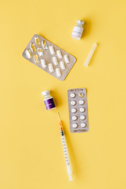Free Variety of Medicines on Yellow Surface Stock Photo