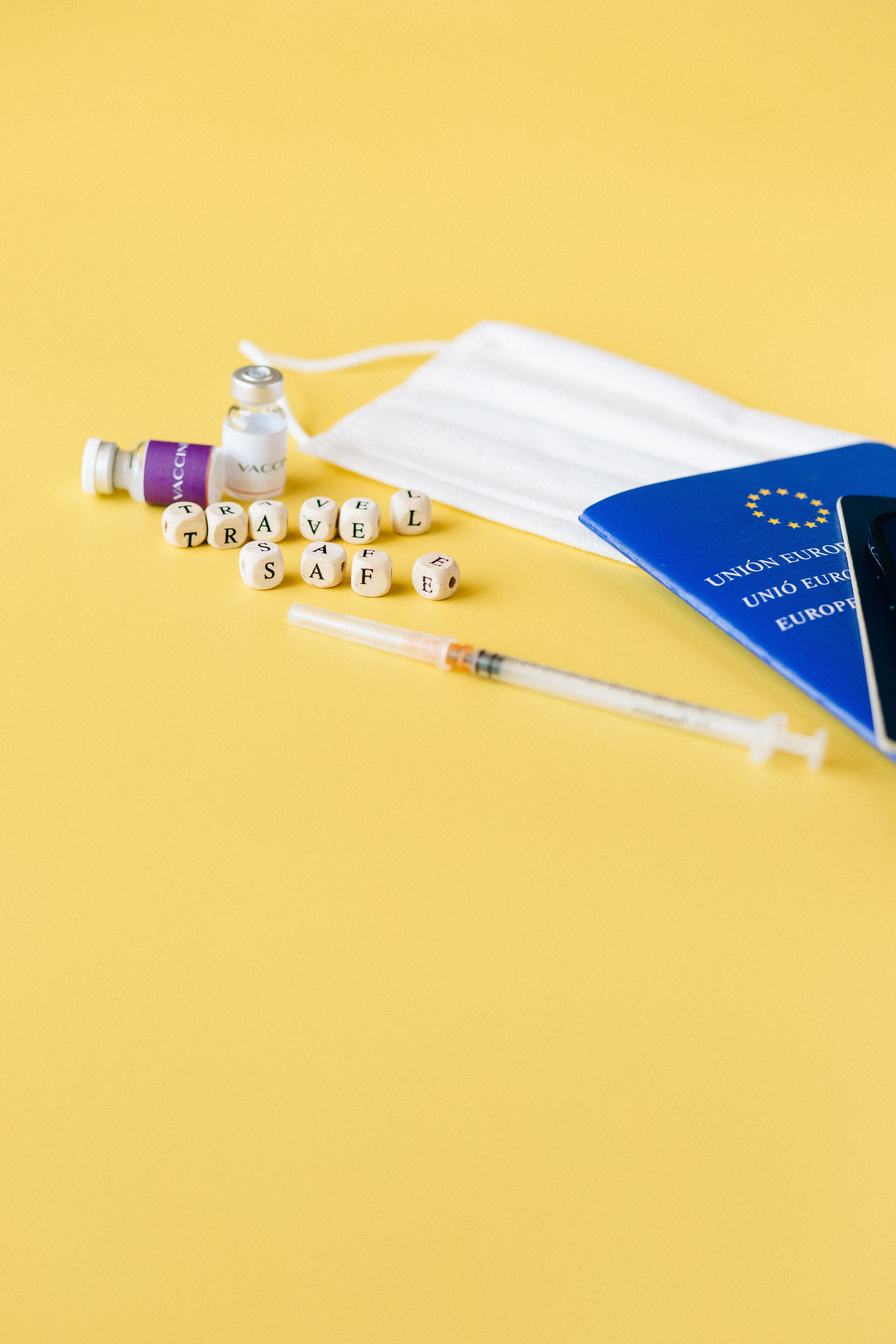 Essential travel safety items including mask, syringe, and passport for a pandemic-ready journey.