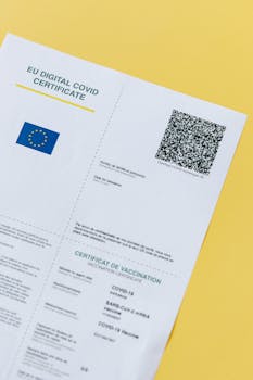 Close-up of an EU Digital COVID Certificate with QR code on a yellow background.
