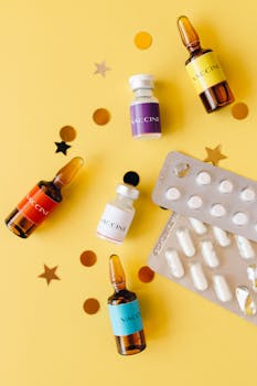 Vibrant still life featuring vaccine vials and pills on a yellow background, ideal for healthcare themes.