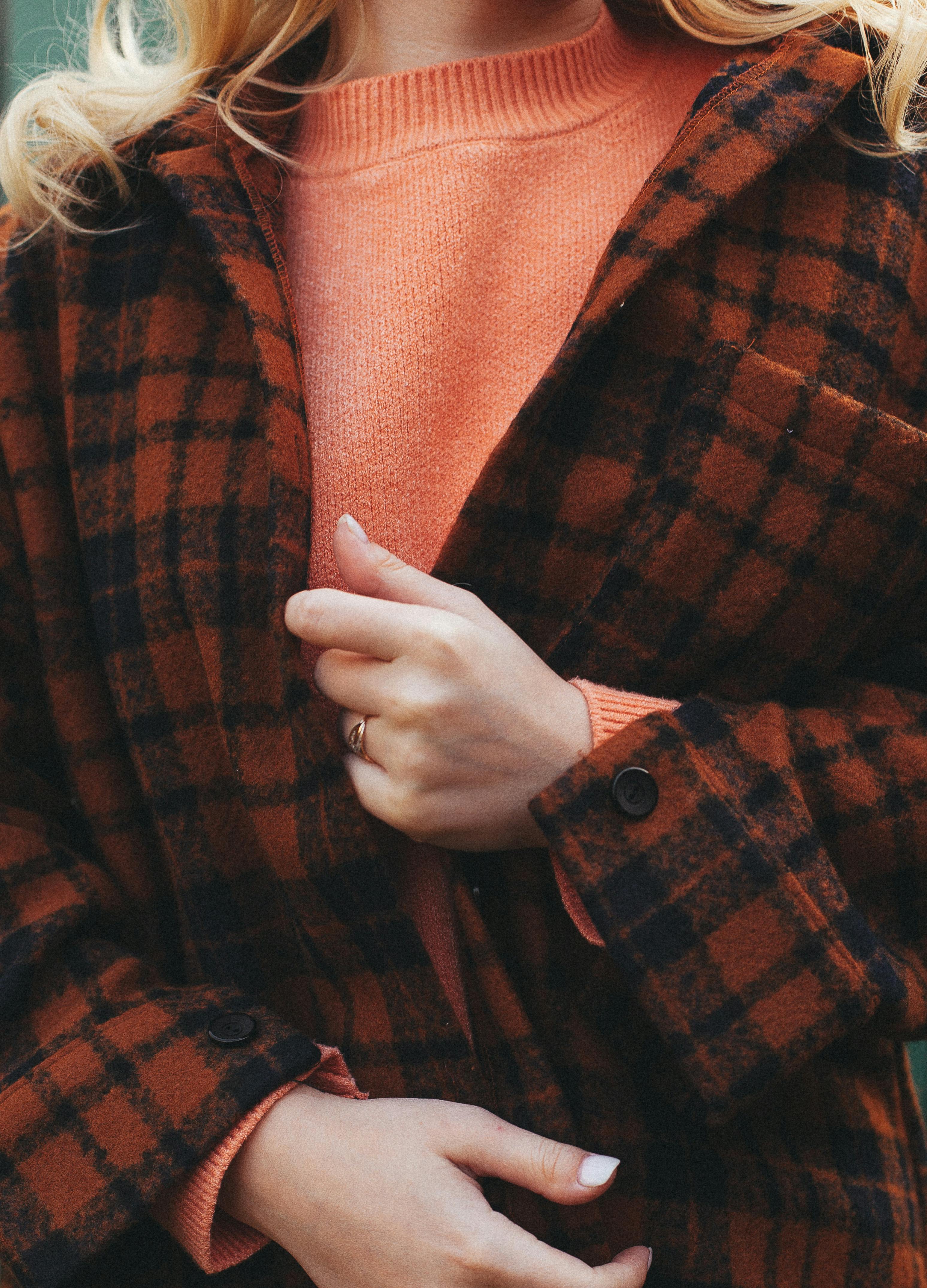 Close-up of a woman in a checkered jacket and sweater, perfect for autumn fashion inspiration.