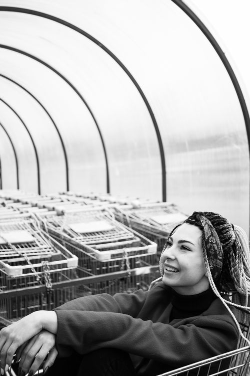 Free Black and white photo of a smiling woman sitting by shopping carts in Moscow. Stock Photo