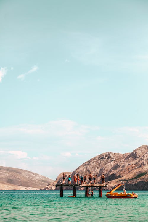 A Group of People Standing on a Platform Surrounded by Water