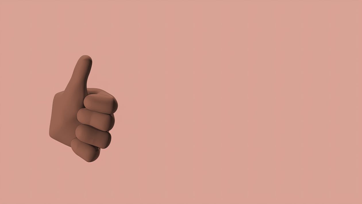Free Hand Doing Thumbs Up Sign in Pink Background  Stock Photo