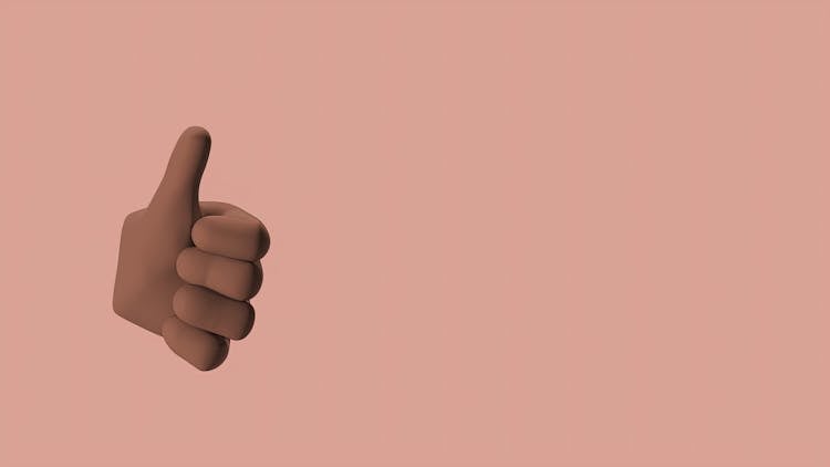 Hand Doing Thumbs Up Sign In Pink Background 