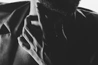 Grayscale Photo of Man Touching his Neck