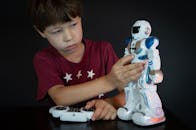Boy Red Shirt Playing a White Robot Toy