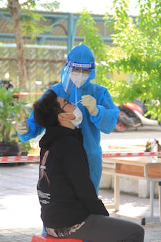 Healthcare worker performs nasal swab COVID-19 test outdoors in Vietnam.