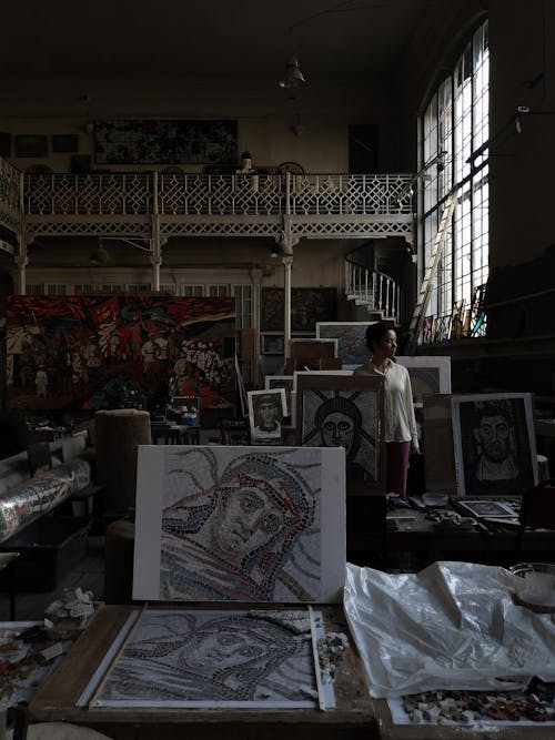 A Woman Standing on a Room Full of Paintings