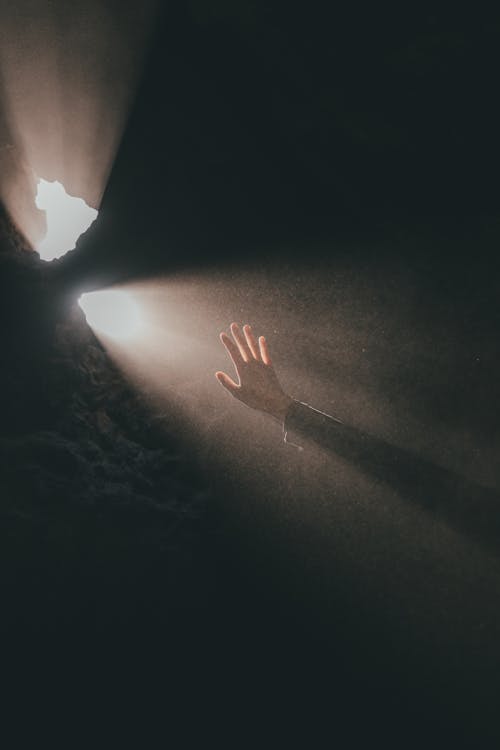 Free A Hand Near the Hole of a Cave with Sunray Stock Photo