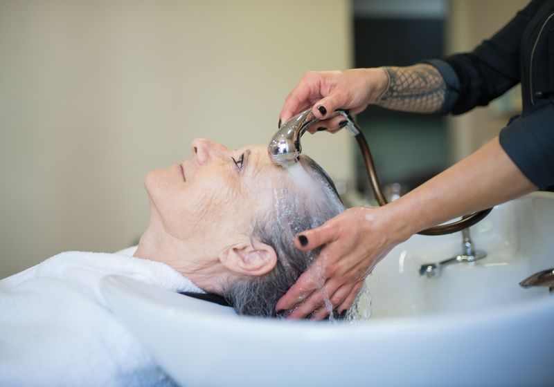 Friseurin bei der Arbeit am Haar einer Kundin