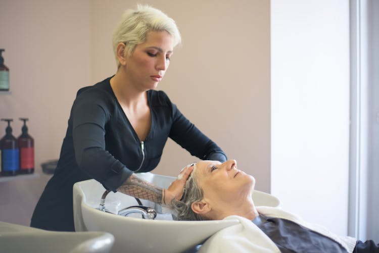 Hairdresser Shampooing An Elderly Client