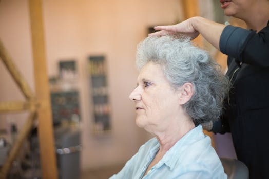 Senior woman gets a haircut at a cozy salon, showcasing personal grooming and care.