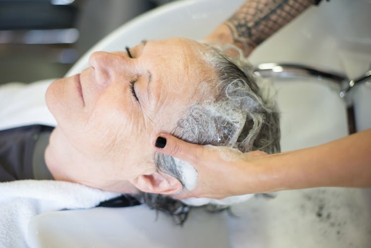 Person Shampooing The Elderly Woman 