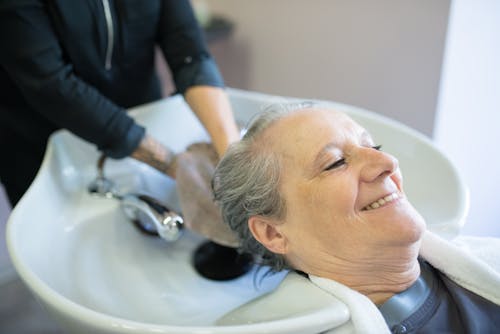 Free An Elderly Woman Having Her Hair Wash Stock Photo
