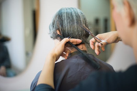 Close-up of a hairstylist cutting a client's hair in a salon.