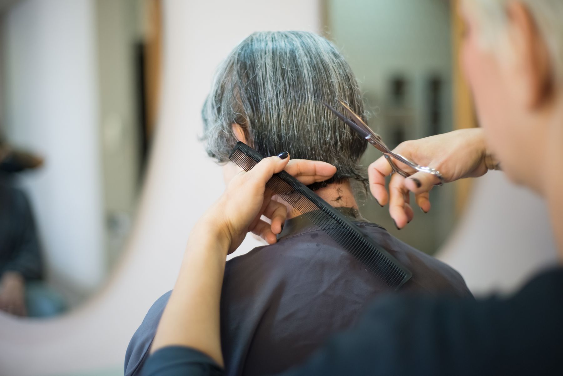 Stylist shaping a client's hair with careful scissor work