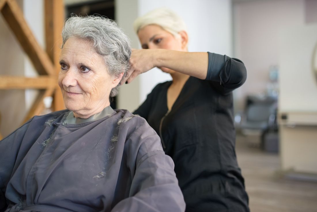 Stylist finishing a precision haircut for a relaxed client