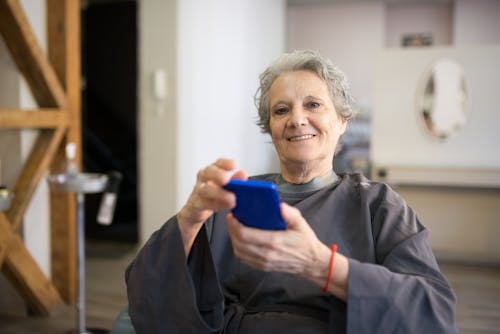 Elderly Woman Holding Phone Looking at the Camera 