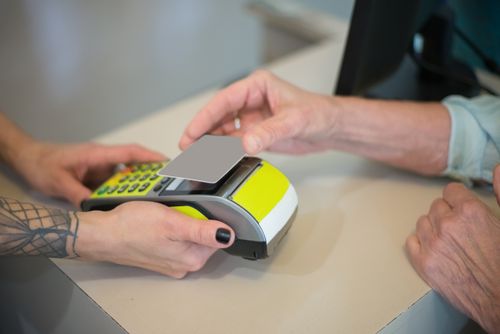 Free Hands using contactless payment on a POS terminal, highlighting cashless transactions. Stock Photo