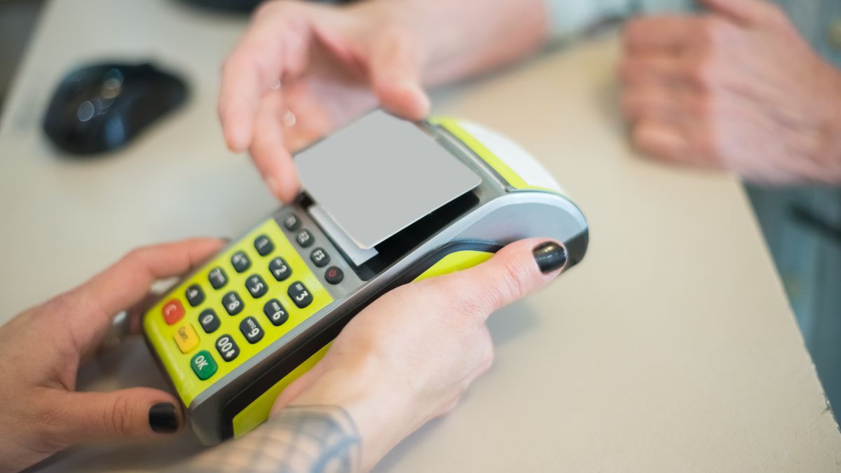 Hands completing a secure card transaction on a terminal