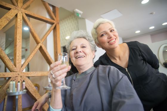 Une coiffeuse souriante avec sa cliente