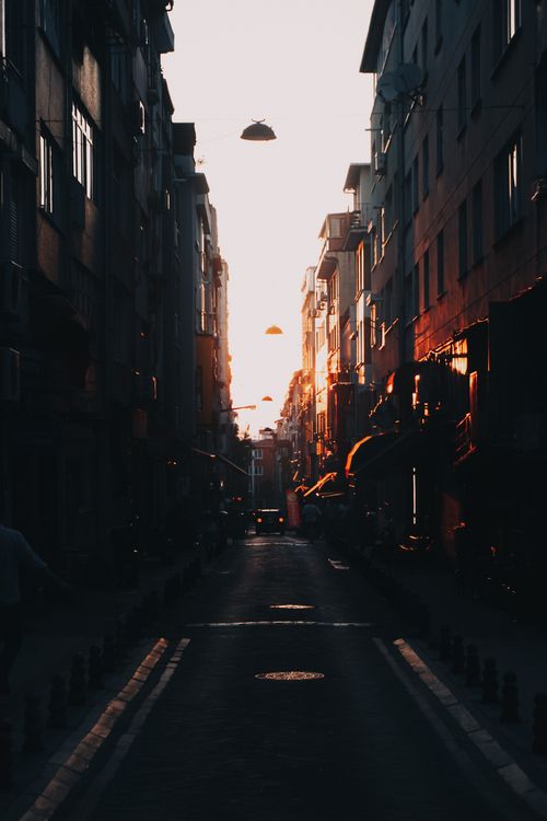 Free Dramatic sunset in Istanbul's narrow street lined with buildings, capturing warm tones and urban vibe. Stock Photo