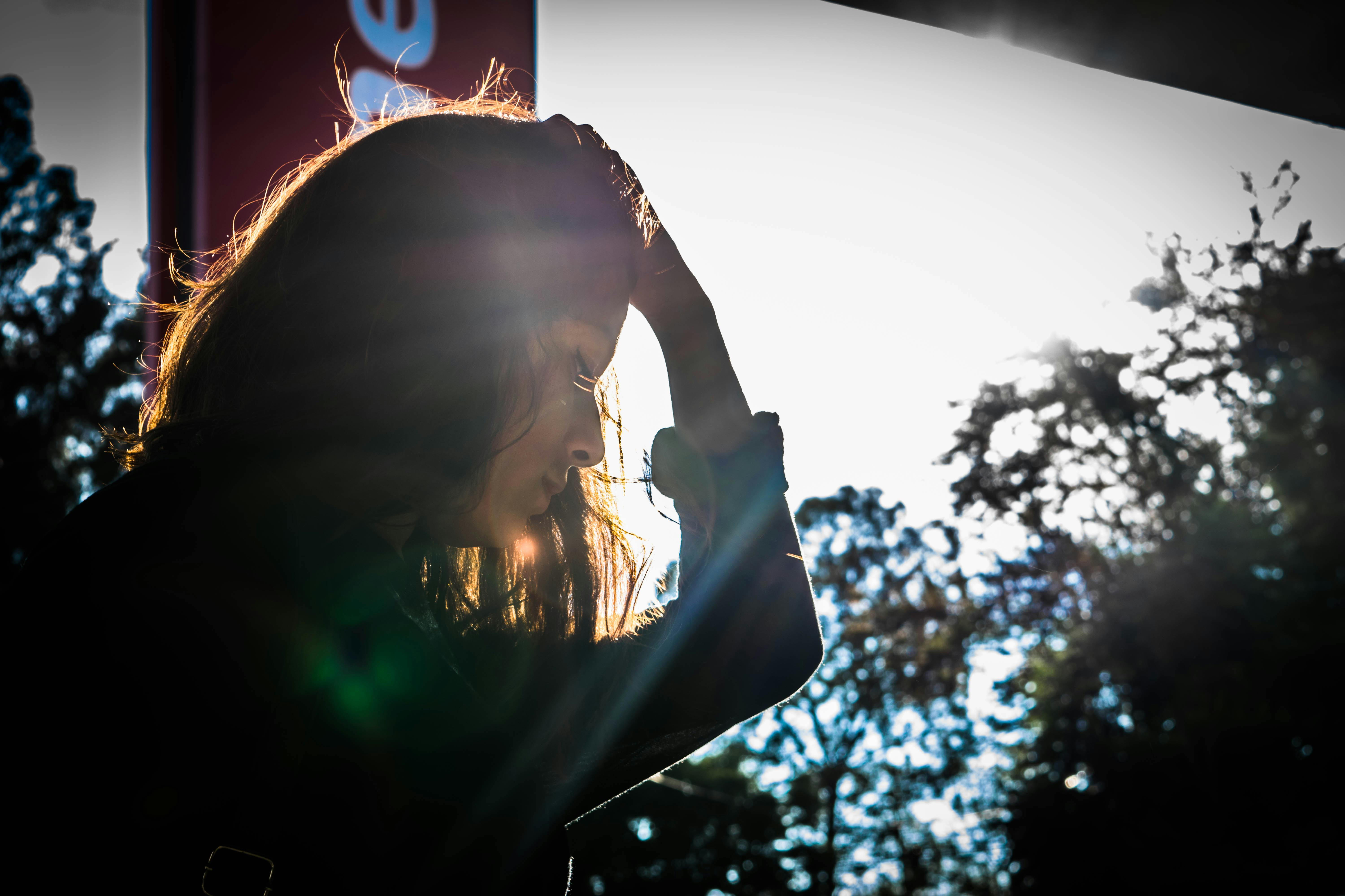 A sad woman holding her head with left hand. | Photo: Pexels