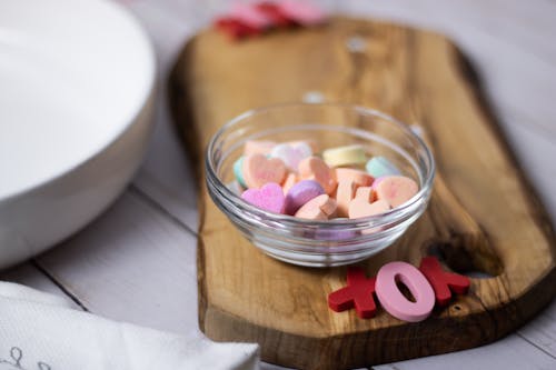 A Bowl of Heart Shaped Candies on a Wooden Surface