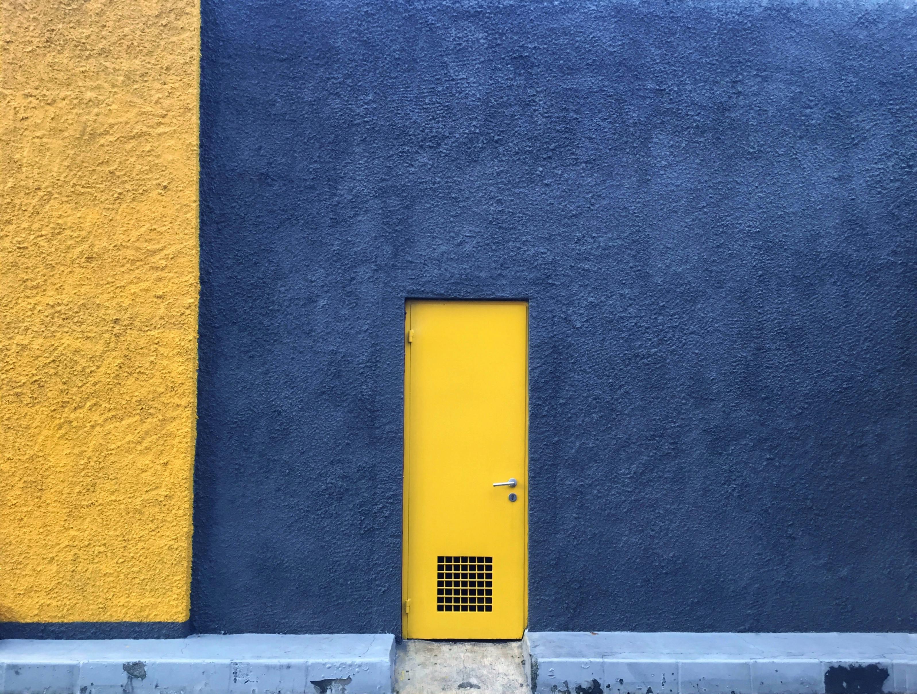 A Yellow Door on the Blue Concrete Wall ?? Free Stock Photo