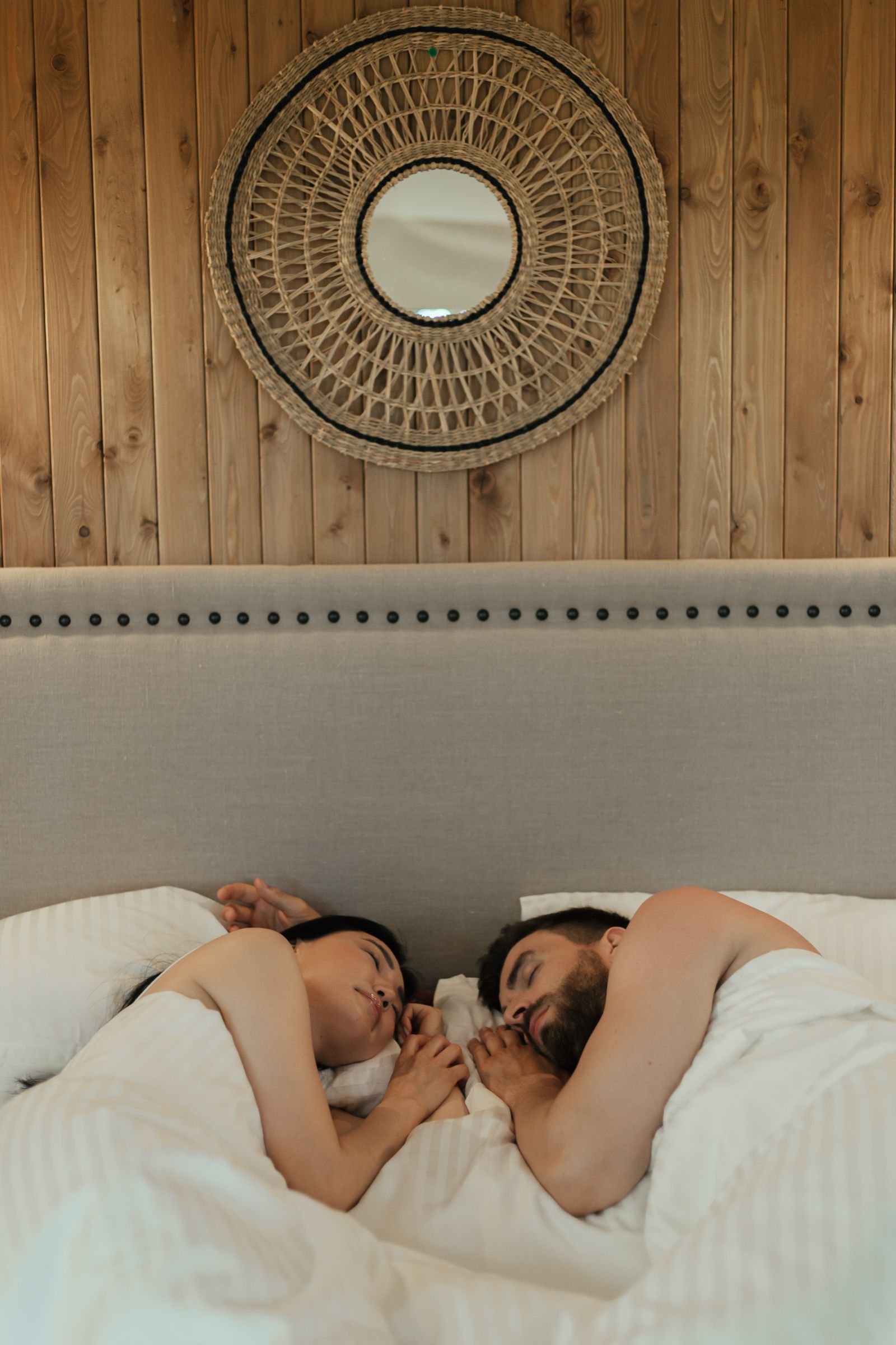Couple resting in bed under a cozy blanket in warm tones