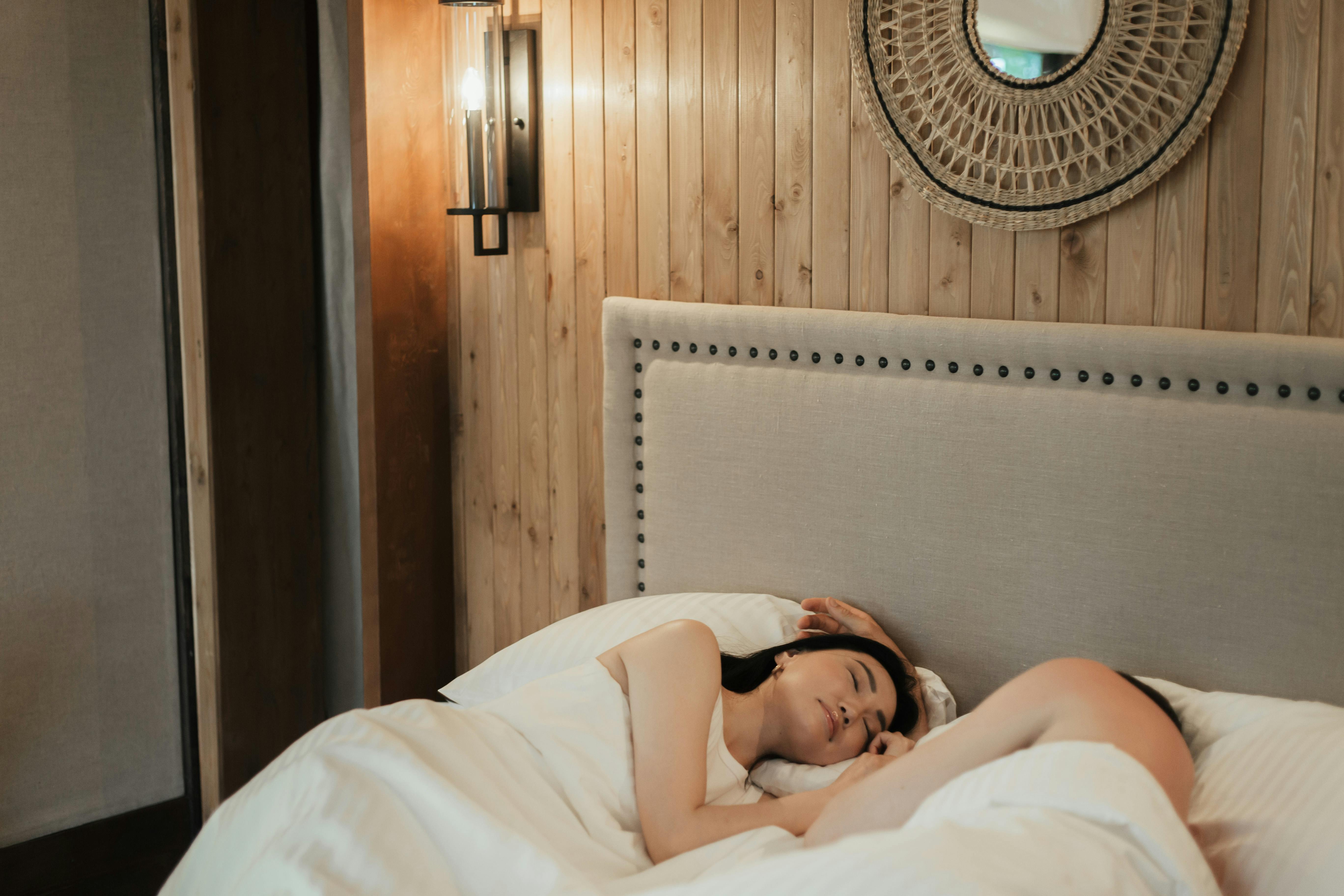 A serene scene of a couple sleeping peacefully in a warm, cozy bedroom.