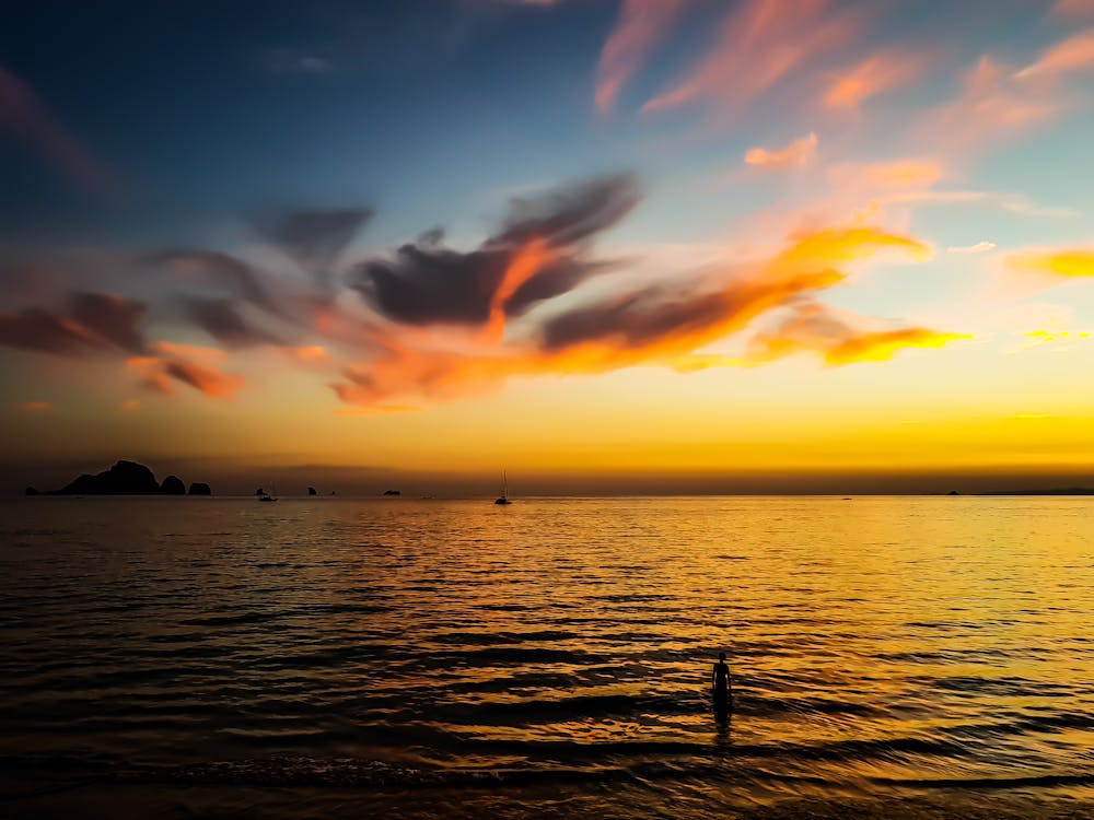 Body of Water Under Calm Sky during Golden Hour