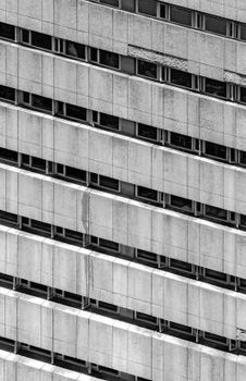 Detailed grayscale view of a modern high-rise building showcasing architectural lines and windows.