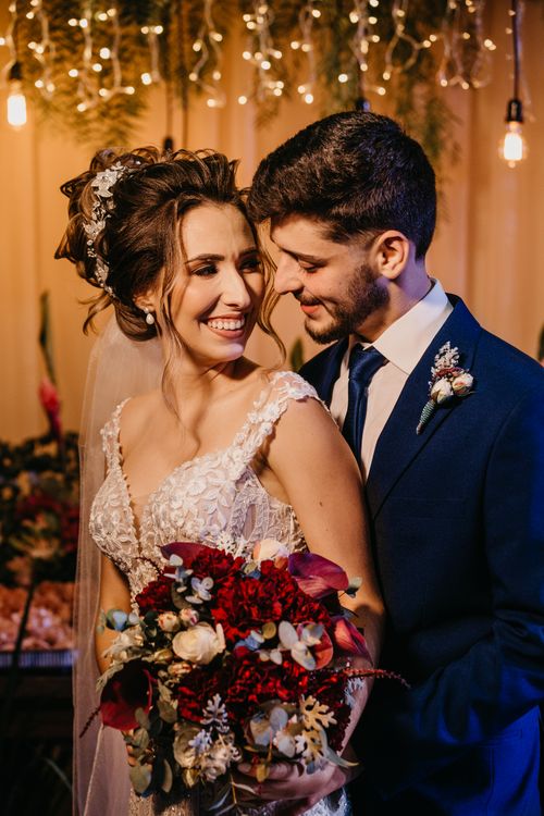 Free A joyful bride and groom smiling at each other on their wedding day, indoors with warm lighting. Stock Photo