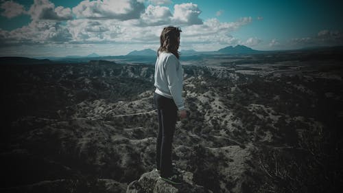 Personne En Chemise à Manches Longues Grise Debout Au Sommet De La Montagne