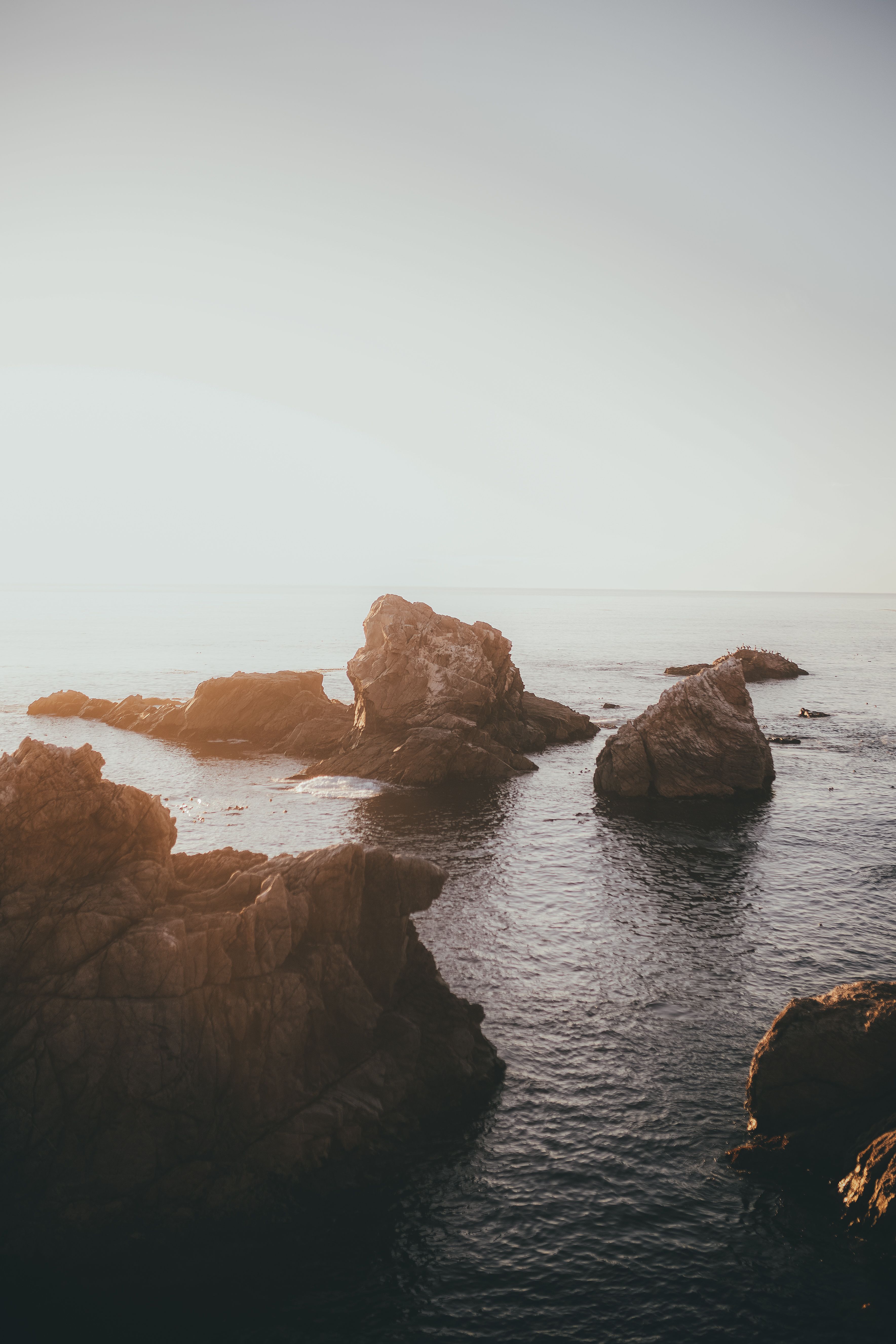 Brown Rocks on Body of Water · Free Stock Photo