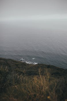 Moody coastal landscape with cliffs and ocean view, invoking tranquility and vastness.