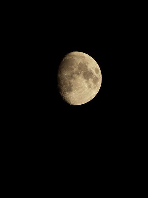 Full moon illuminating in darkness in sky