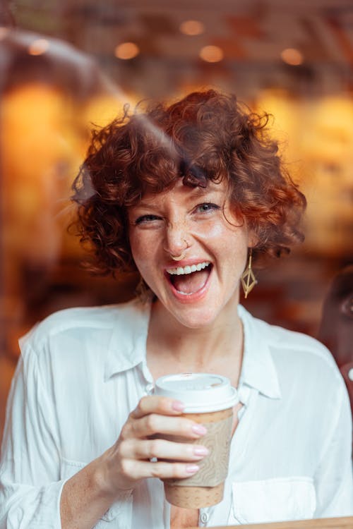 Woman with Red Curly Hair Holding a Cup of Coffee