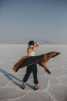 A woman striking a dramatic pose on vast salt flats, adding a sense of motion.